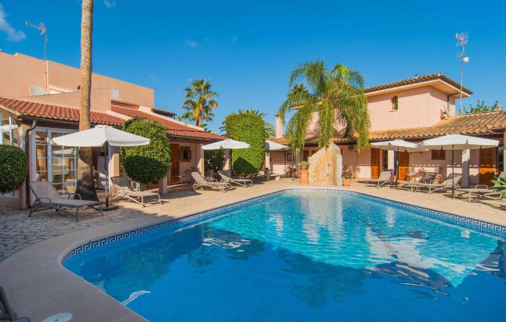 a swimming pool in front of a house at Casa Romantica De Sa Coma in Sa Coma