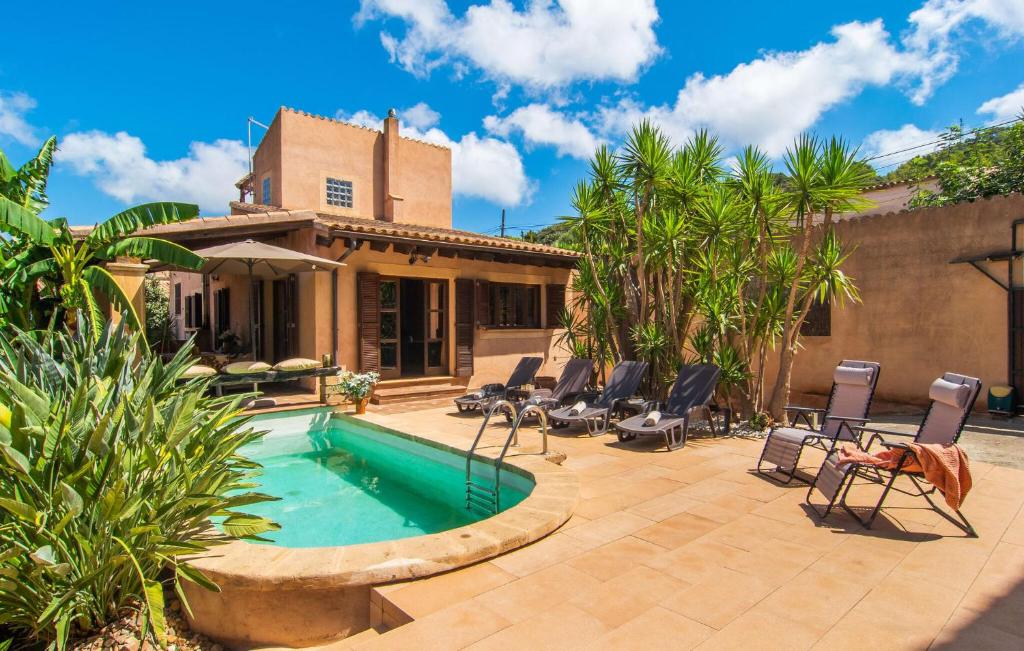 eine Terrasse mit Pool und Stühlen und ein Haus in der Unterkunft Es Regaro in Capdepera