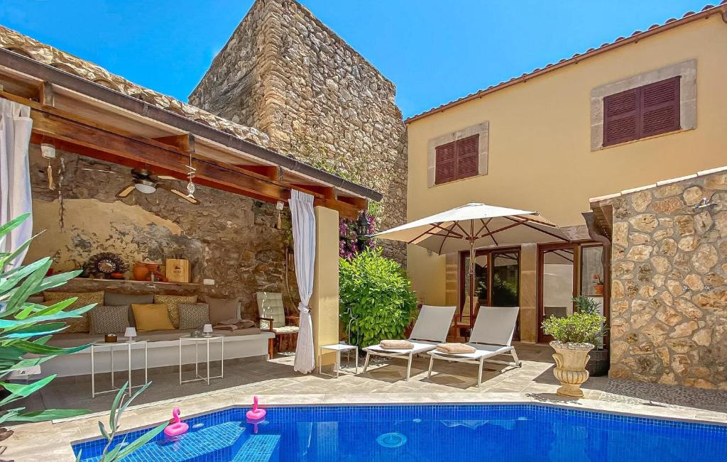 a patio with chairs and an umbrella next to a pool at Casa Vida Arta in Artá