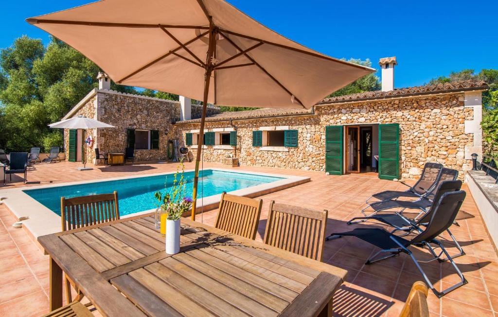 a patio with a wooden table and an umbrella at Can Baldo in Sencelles