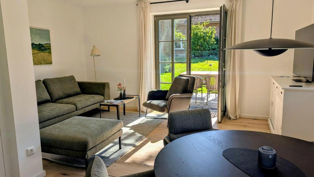 a living room with a couch and a table at Ferienhaus Ovis Natur, Ruhe und Erholung in der Lüneburger Heide, Hunde willkommen in Winsen