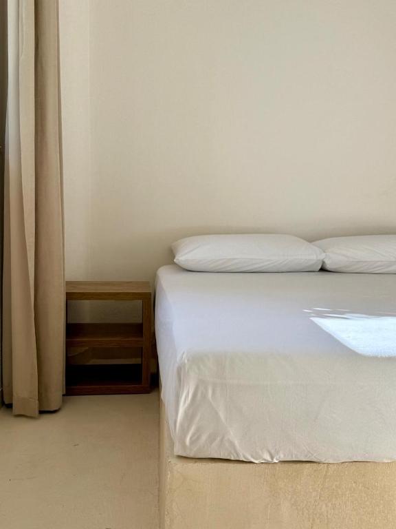 a bedroom with a white bed and a night stand at SĀN Living in Golem
