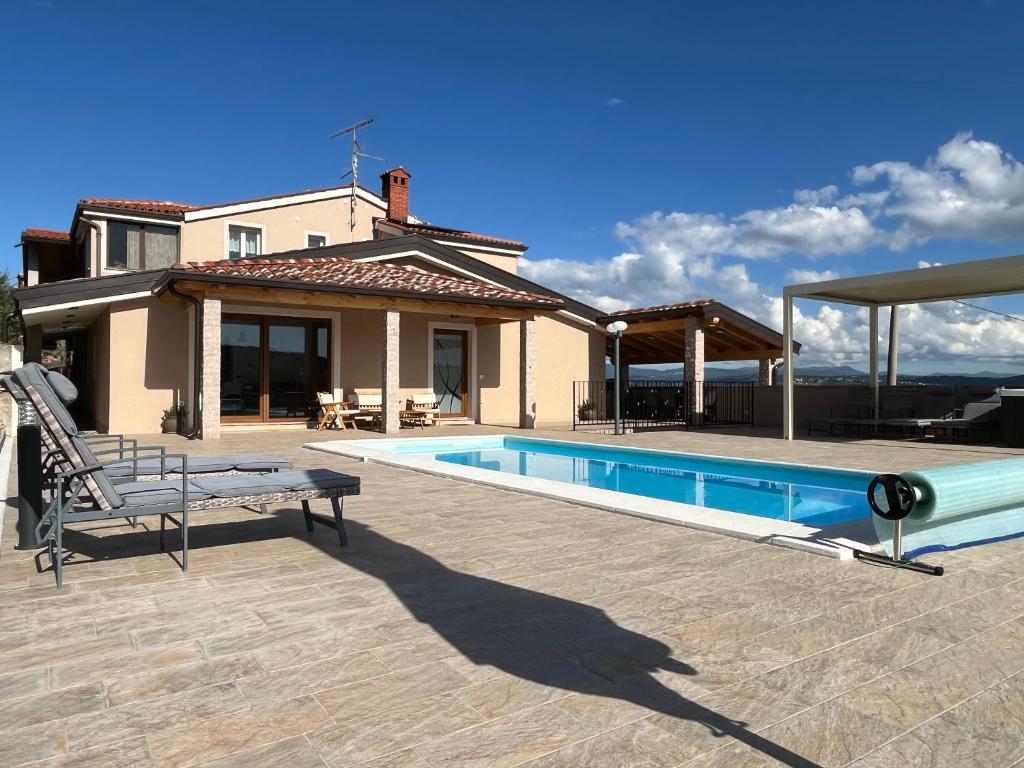 a house with a swimming pool in front of a house at Apartma Rozi Deluxe in Koper