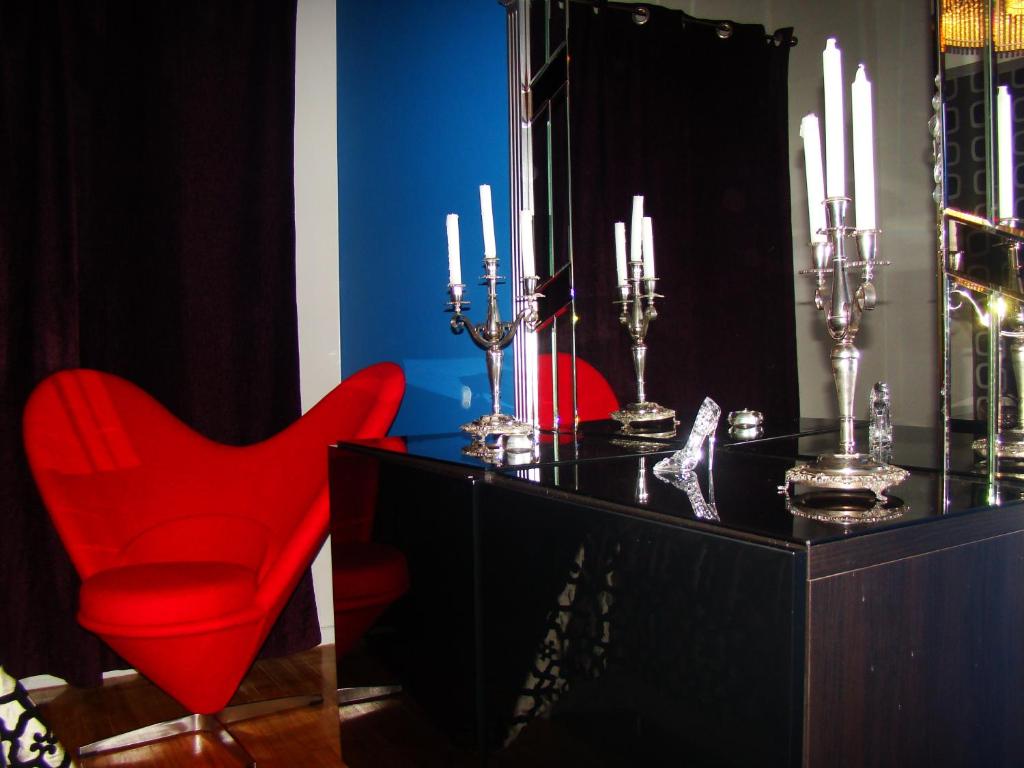 a red chair and a black dresser with a mirror at Lux Apartment in Lisbon