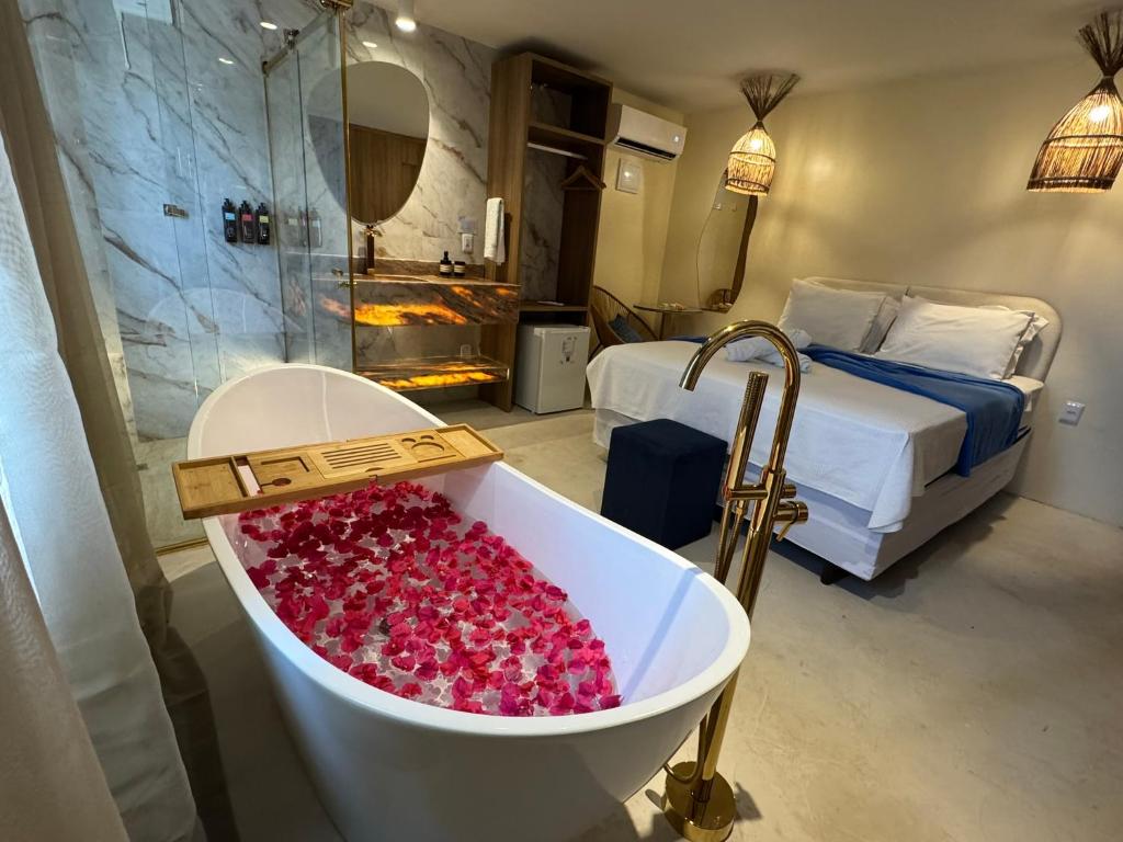 a bath tub filled with pinkberries in a hotel room at Creta Boutique Hotel São Luís in São Luís