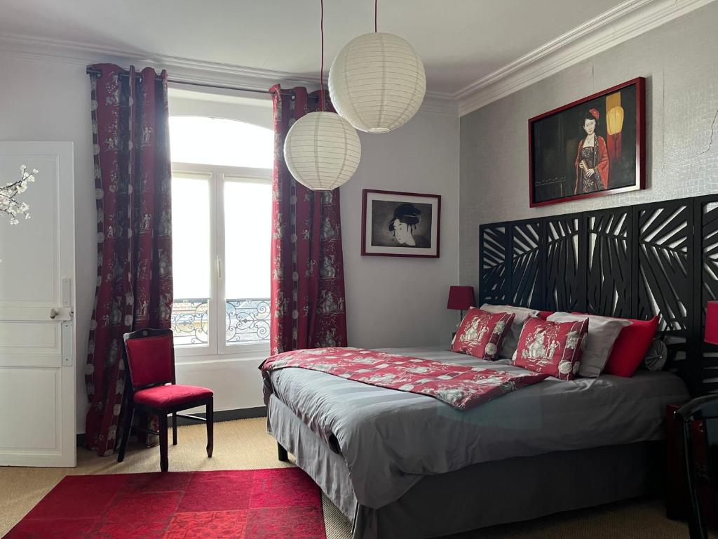 a bedroom with a large bed and a red rug at Les Lamartine-chambres d'hôtes in Le Mans