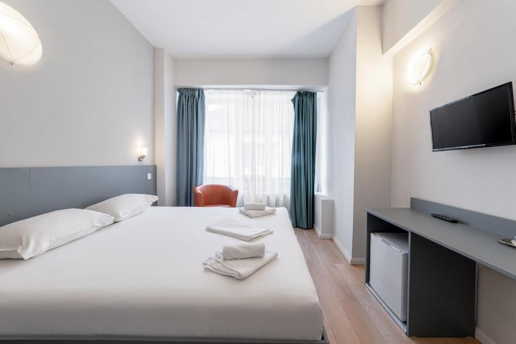 ein Hotelzimmer mit Bett und Flachbildfernseher in der Unterkunft Elizeu Hotel in Bukarest