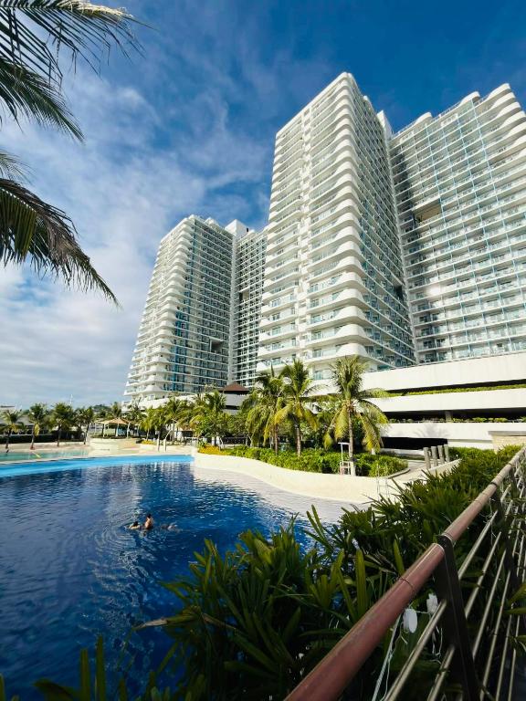 a hotel swimming pool in front of tall buildings at Azure North - Aurora Sky in San Fernando