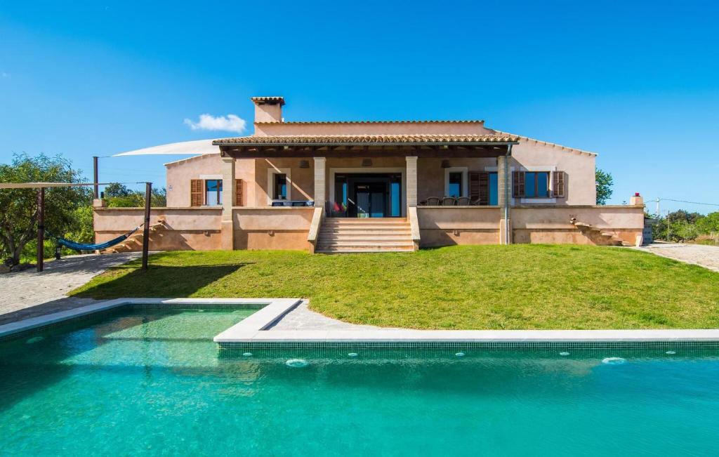 a house with a swimming pool in front of a house at S'oratge in Artá