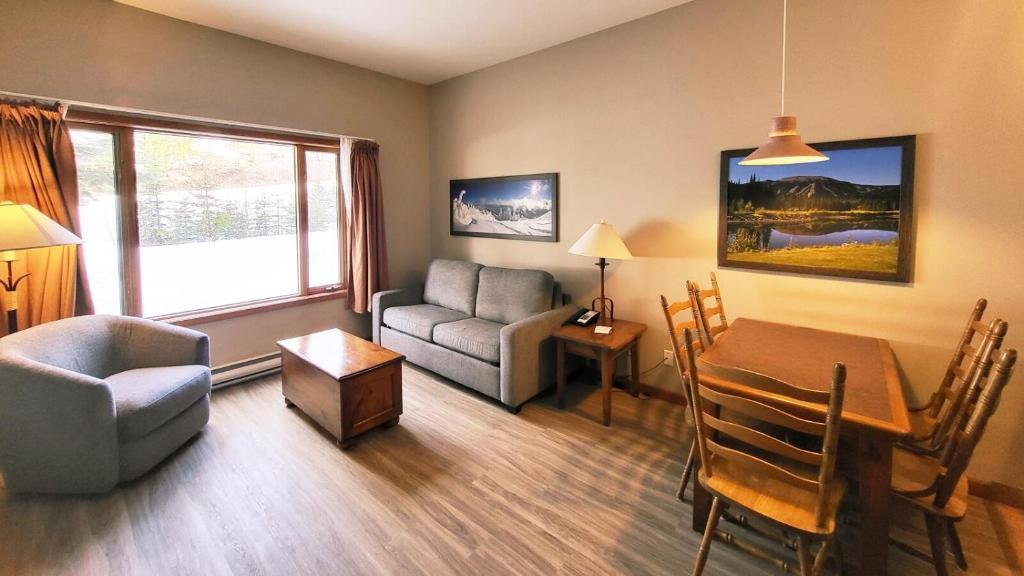 a living room with a table and a chair and a couch at Cahilty #103 in Sun Peaks