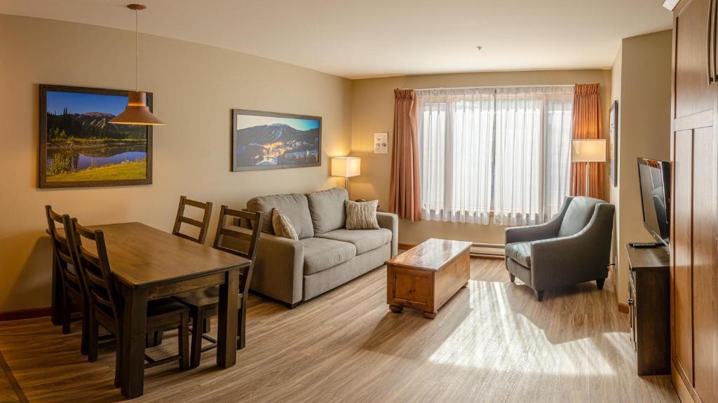 a living room with a couch and a table and a dining room at Cahilty #204 home in Sun Peaks