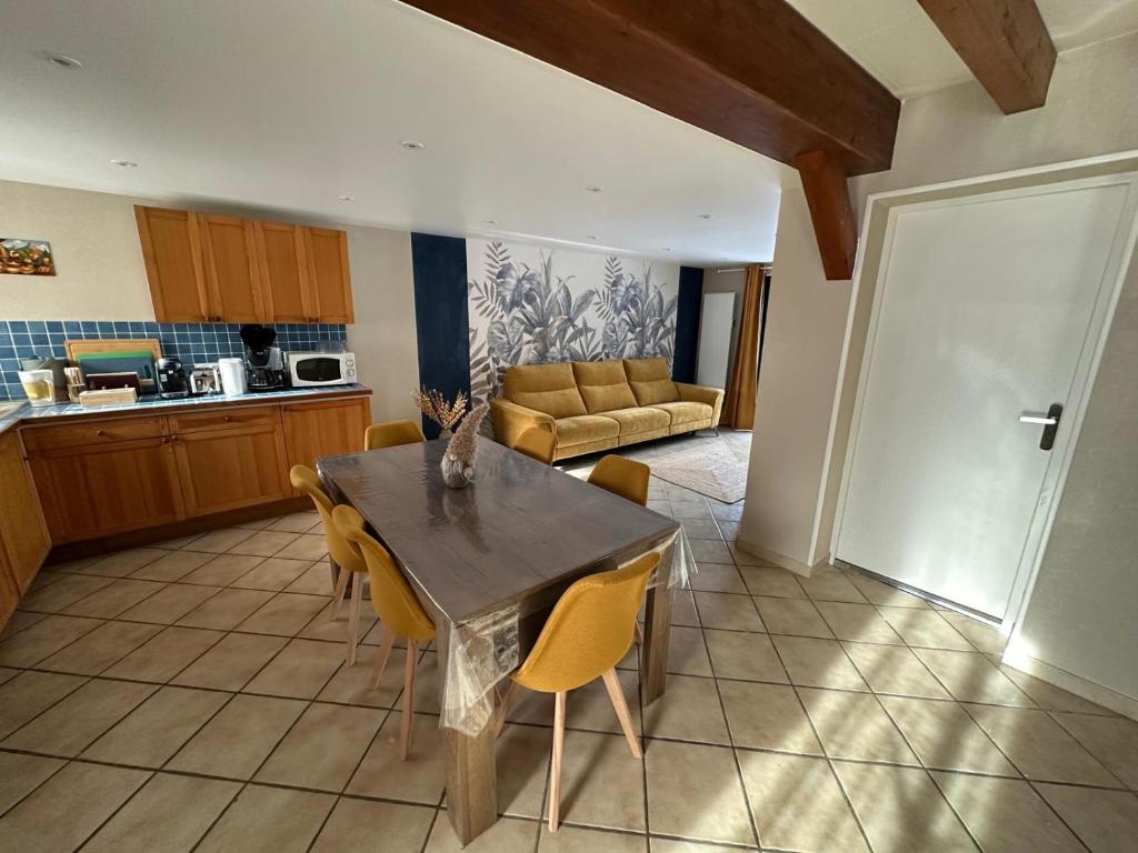 a kitchen with a table and chairs and a couch at Le Nid de Chartreuse in Saint-Christophe