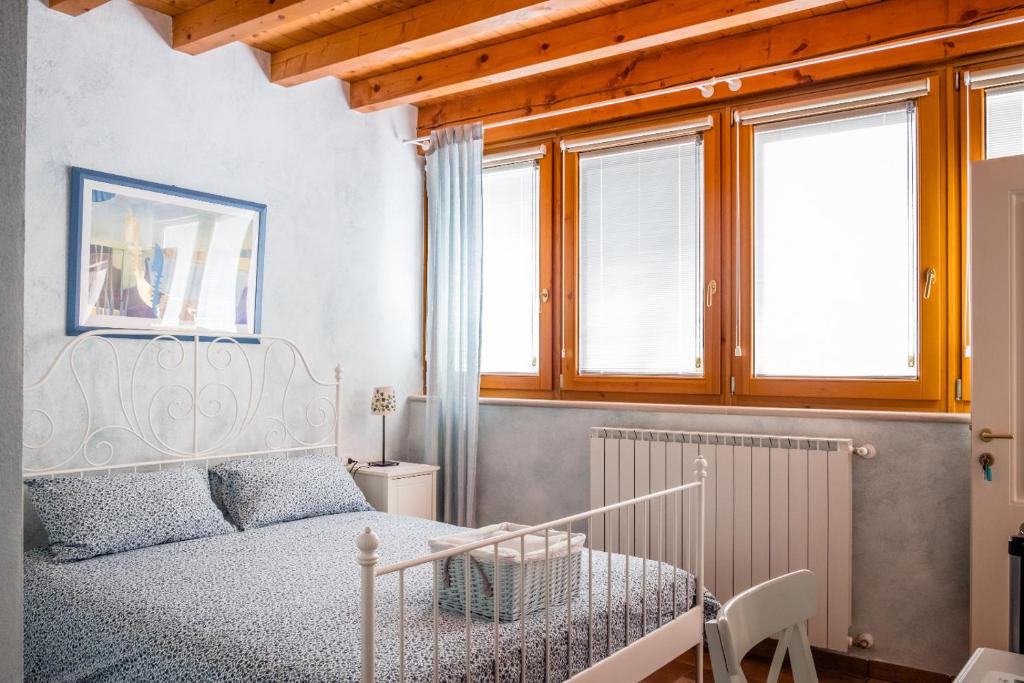 a bedroom with a white bed and windows at Bed & Breakfast Carpe Diem in Solferino