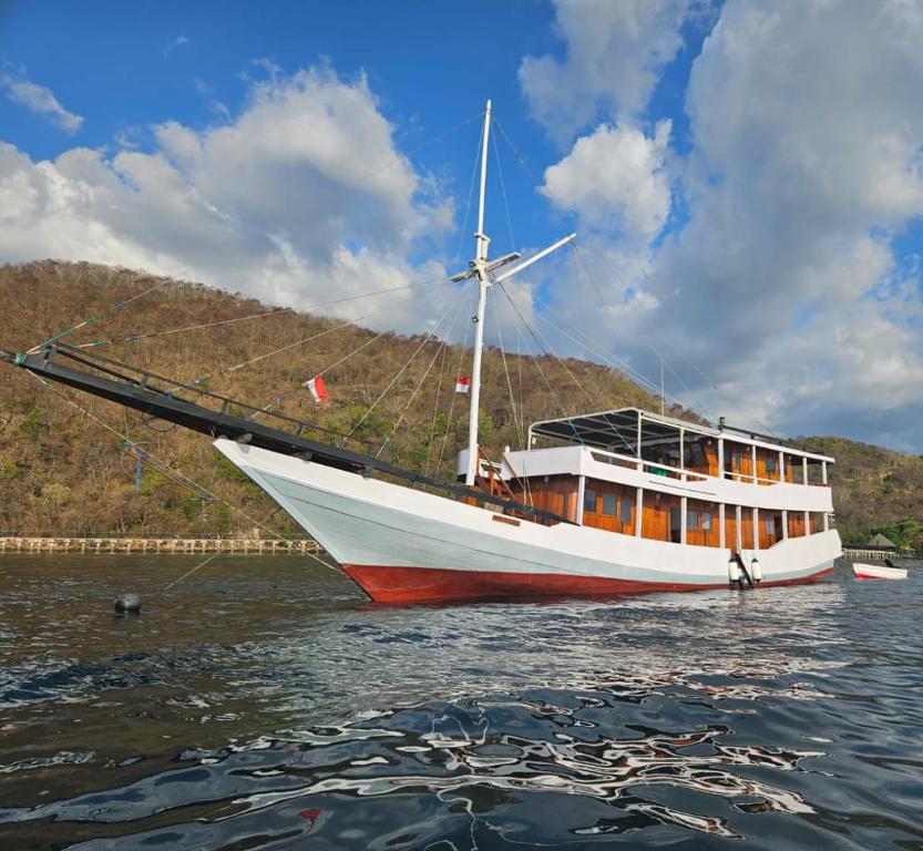 a boat in the water with a windmill on it at Sharing trip komodo 3d 2n in Labuan Bajo