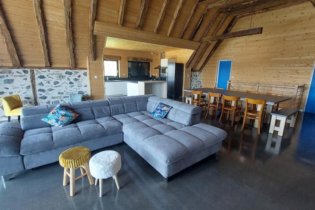a living room with a blue couch and a table at La grange du vezou in Paulhenc