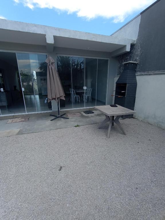 a patio with a bench and an outdoor oven at Casa 2 quartos a 2 quadras do mar nova in Matinhos