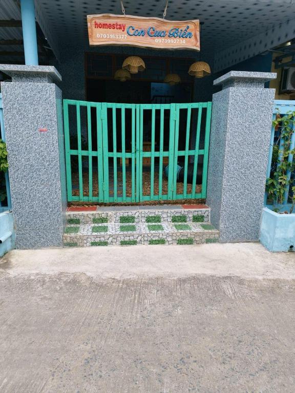 a green gate in front of a building at Con Cua Biển Homestay in Tuy Hoa