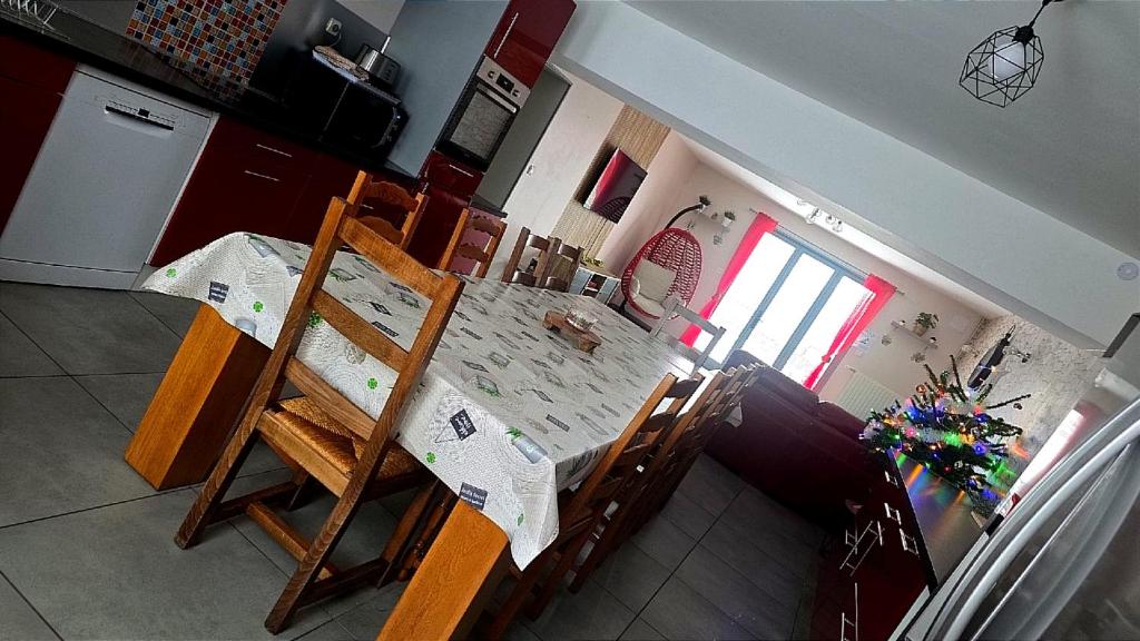 a kitchen with a table and chairs in a kitchen at Aux P'tits Cabris in Lahayville