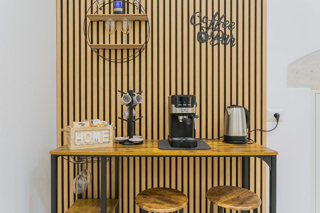 a table with two stools and a coffee maker on it at Il borgo incantato in Bitonto