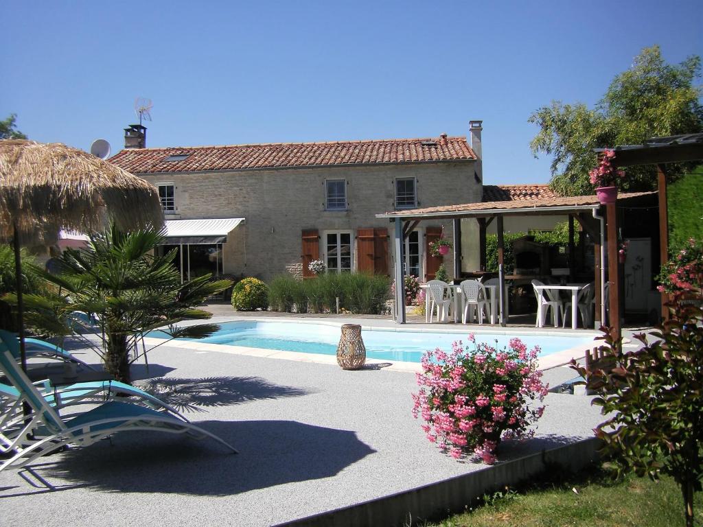 a villa with a swimming pool and a house at Au Fil de l'Eau in La Ronde