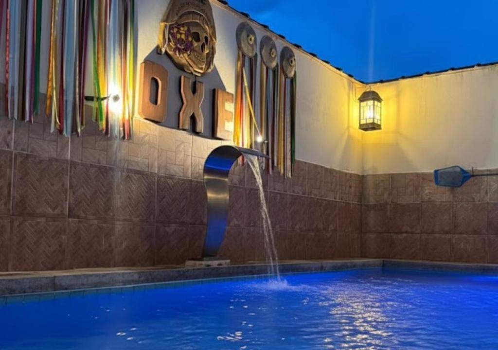 a swimming pool with a water fountain in a building at Hostel Ôxe in Paraty