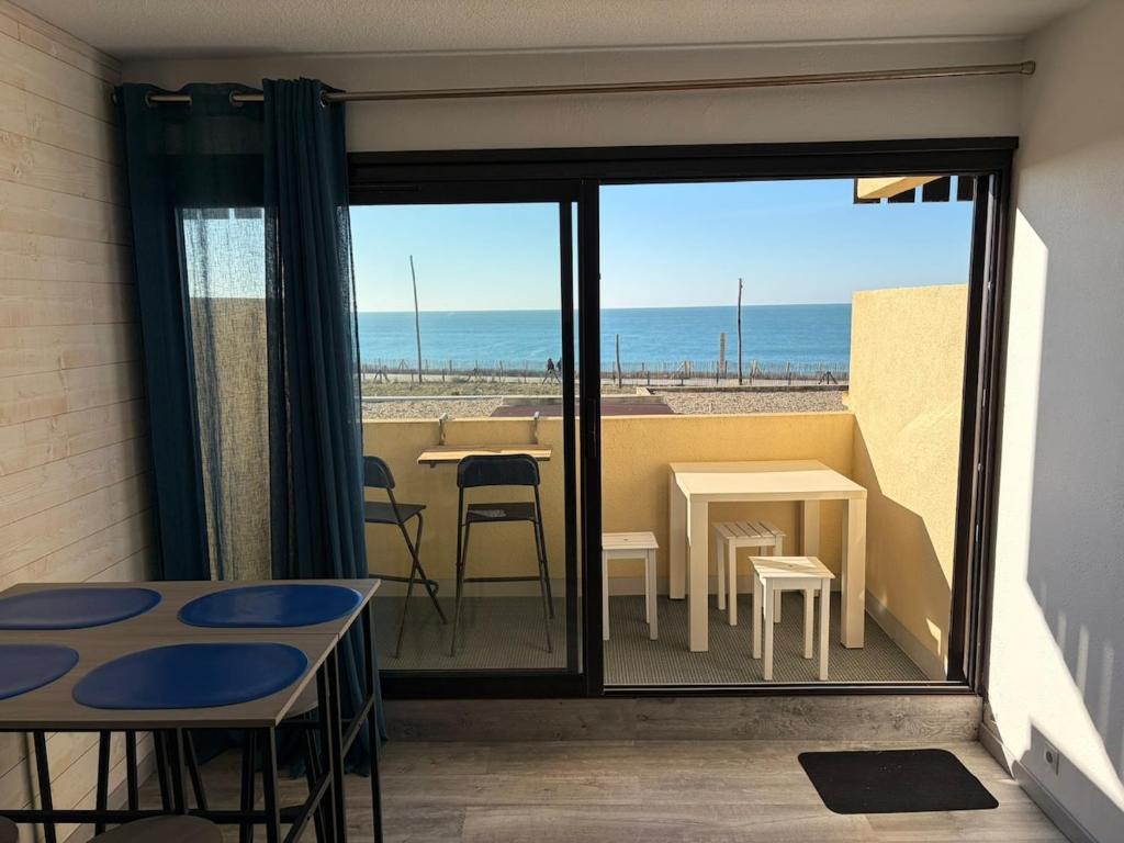 a room with a balcony with a view of the ocean at Appartement face océan in Lacanau