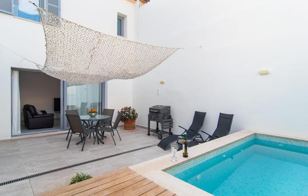 a house with a swimming pool and a table and chairs at Petit Arta - Sa Botigueta in Artá