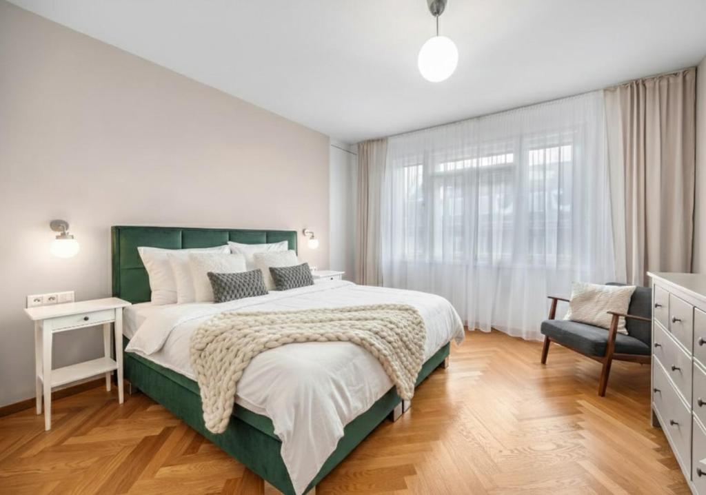 a bedroom with a large bed and a chair at Modern old town apartment in Bratislava