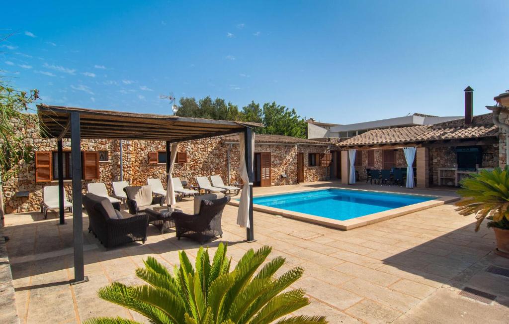 a patio with a pool and chairs and a house at S'hortet in Campos