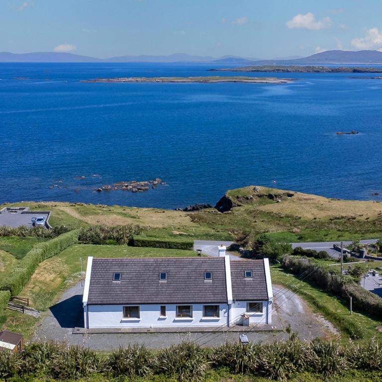 a house on a hill next to the water at Renvyle Sea for Miles in Renvyle