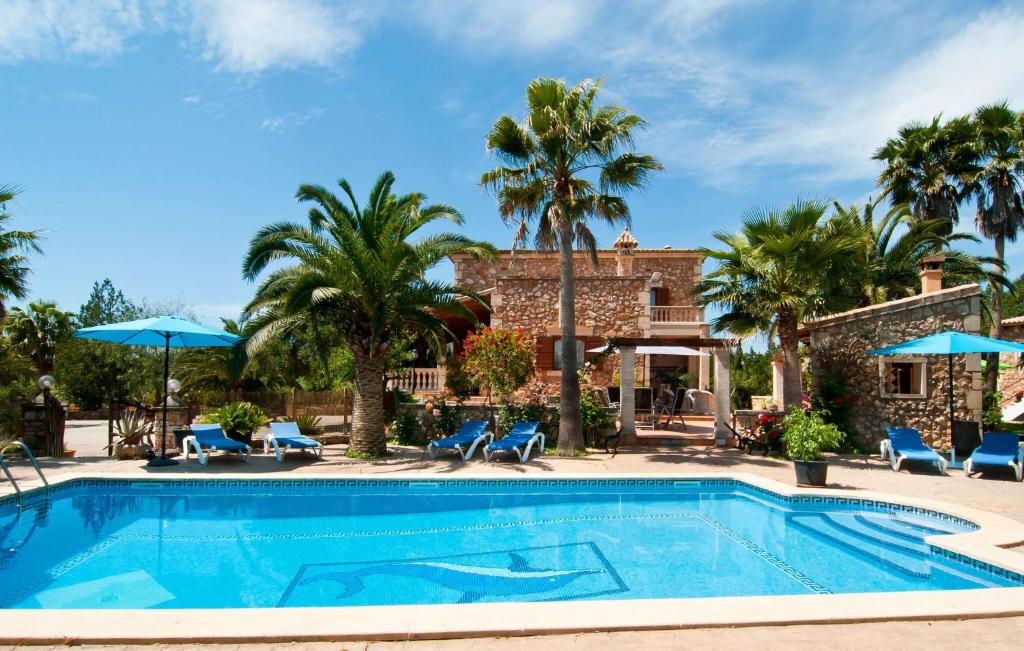 a pool at a resort with palm trees and chairs at Can Lopez Vara in Campos