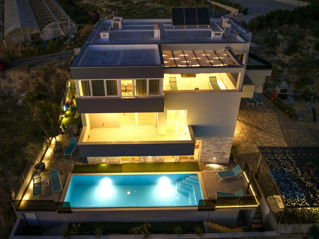 an aerial view of a house with a swimming pool at Apartman Palma and Luxury Penthouse for a family with swiming pool,parking,terrace,panoramic view at the sea,Podstrana in Podstrana