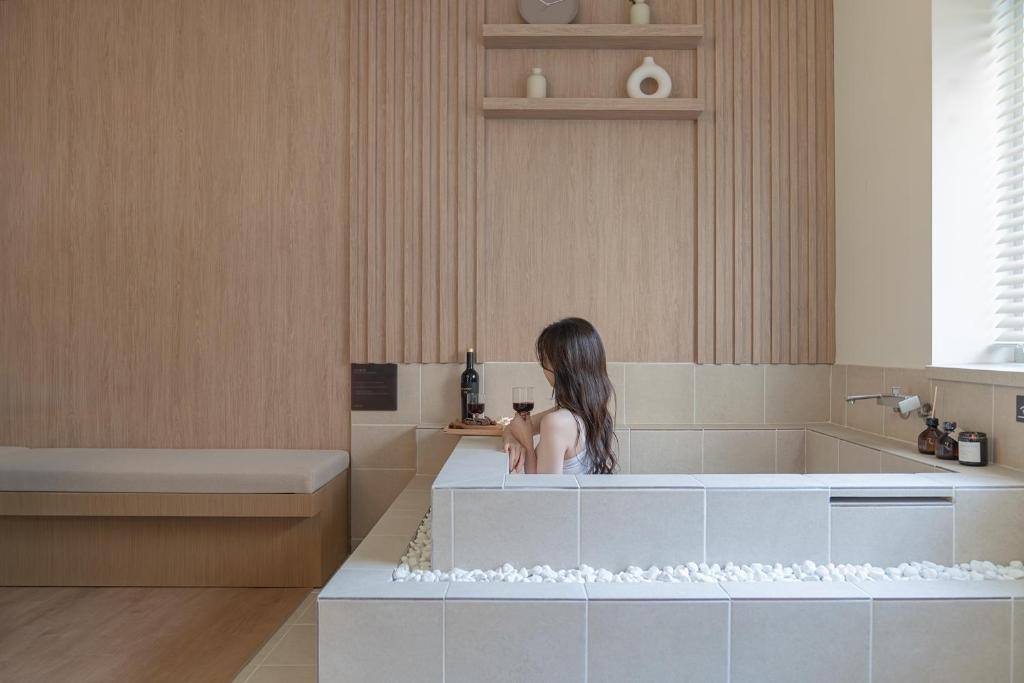 a young girl sitting in a tub in a bathroom at 하로스테이 신사점 in Seoul
