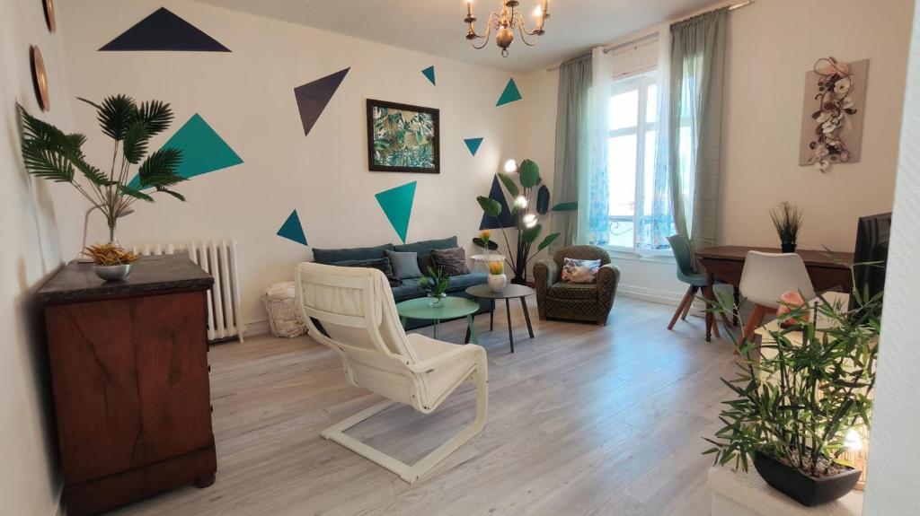 a living room with a chair and a table at Cosy Jade - Quartier Vivant du Chateau - Parking souterrain in Pau