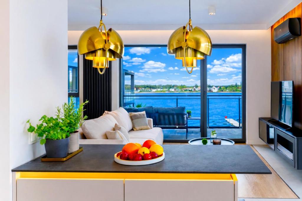 a living room with a table with fruit on it at Marina Ostróda - 80 metrów luksusu z widokiem na jezioro in Ostróda