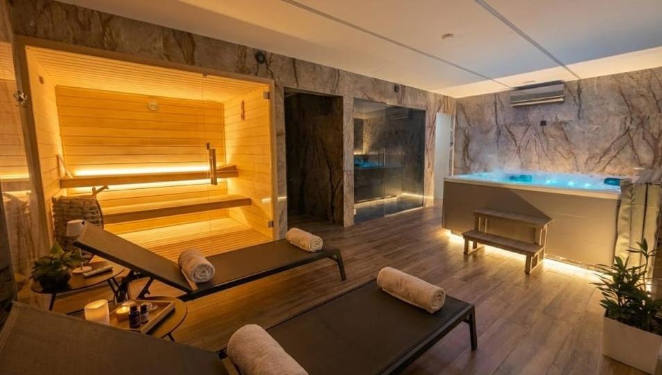 a large room with a tub and a swimming pool at Arouca Passadiços Alojamento & Jacuzzi - SPA in Arouca