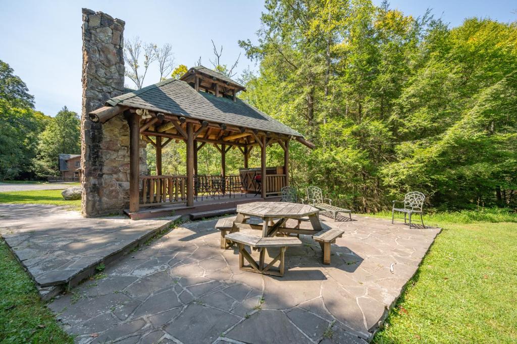 a wooden gazebo with a picnic table and benches at Viva By The Stream by Railey Vacations in McHenry