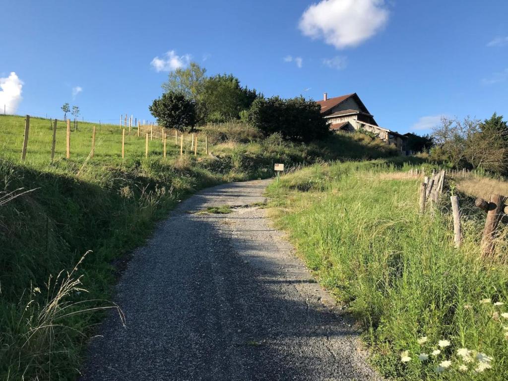 a dirt road in a field with a house at Joz Une Halte in Saint-Antoine