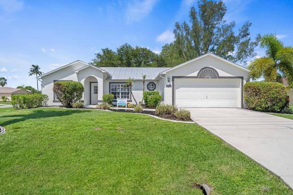 a large white house with a driveway at Villa Yvonne in Cape Coral