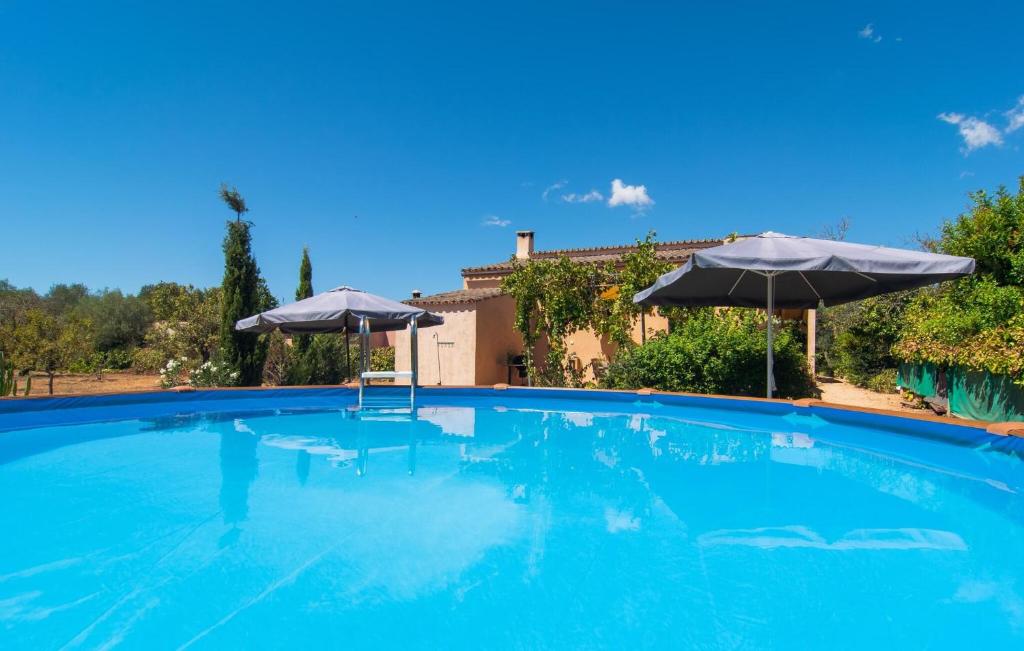 a large swimming pool with two umbrellas at Cas Nets in Llucmajor