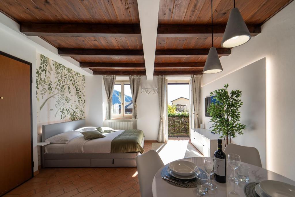 a bedroom with a bed and a table and chairs at Bright apartment with private garage in Cernobbio