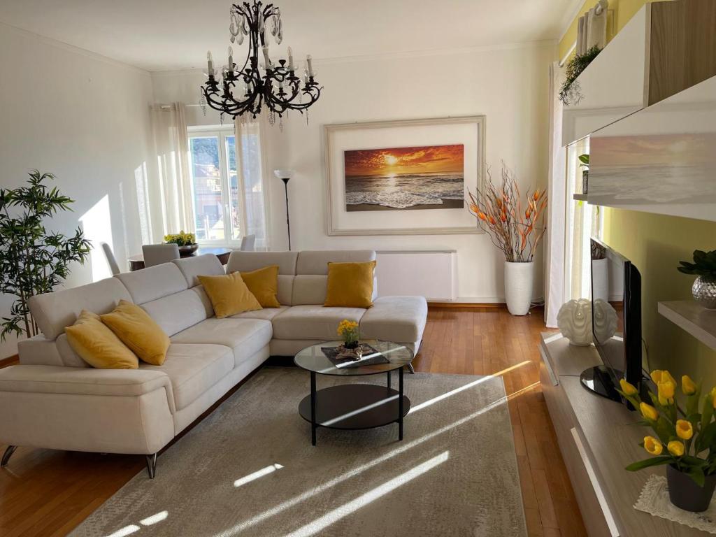 a living room with a white couch and yellow pillows at Casa Riviera in Lavagna