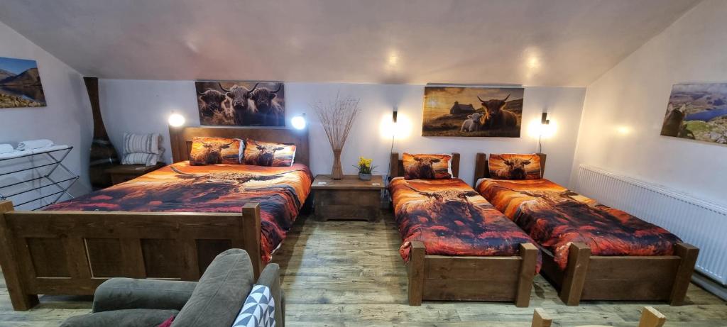 a bedroom with two beds and a couch at Windsor Cottage on The Big "W" Ranch in Nether Wasdale