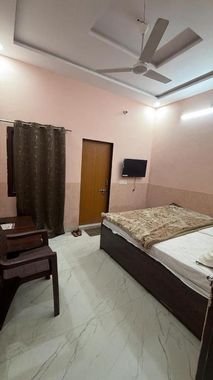 a bedroom with a bed and a ceiling fan at Amrit Guest House in Vrindāvan