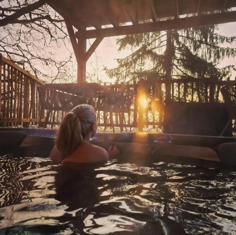 a woman is sitting in a hot tub at Le château des fées in Illoud