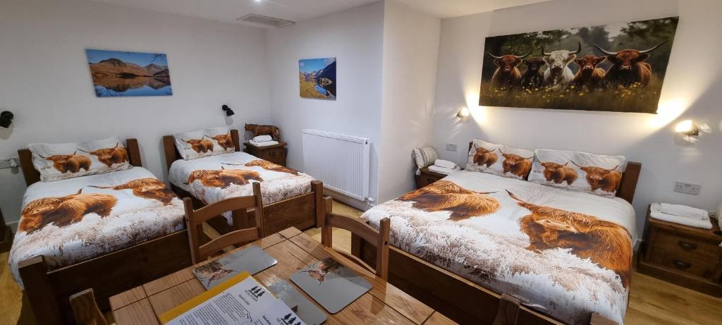 a room with two twin beds and a painting on the wall at Wastwater Cottage on The Big "W" Ranch in Nether Wasdale