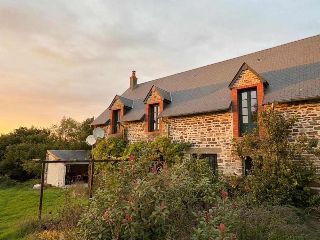 a brick house with a black roof at Le petit Valet in Saint-Clément