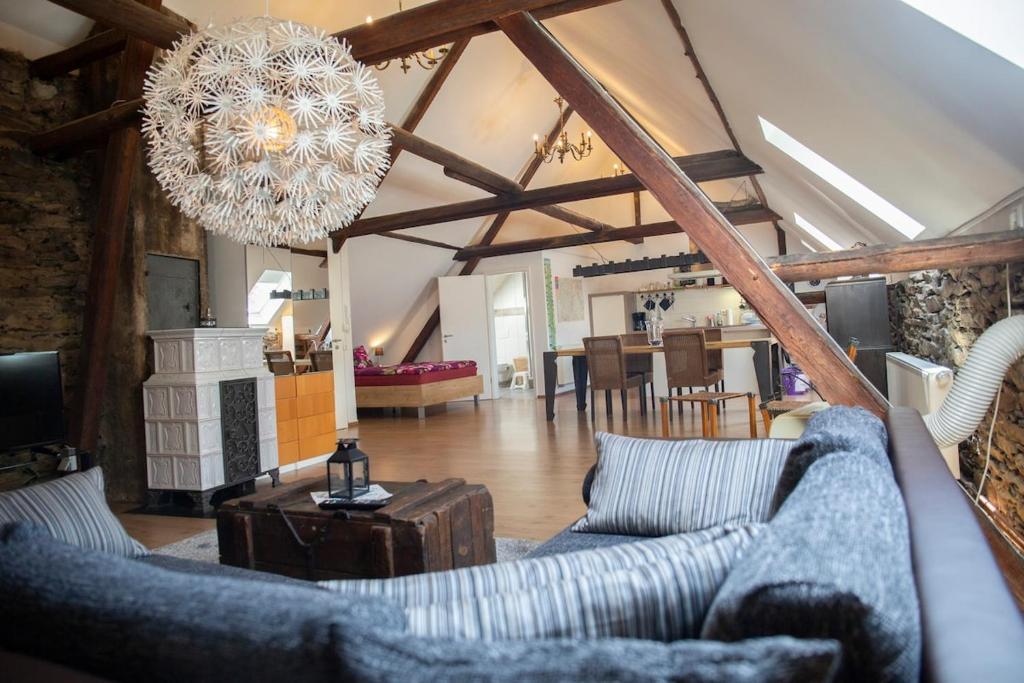 a living room with a couch and a chandelier at Ferienhaus zum Brauneberg in Klotten