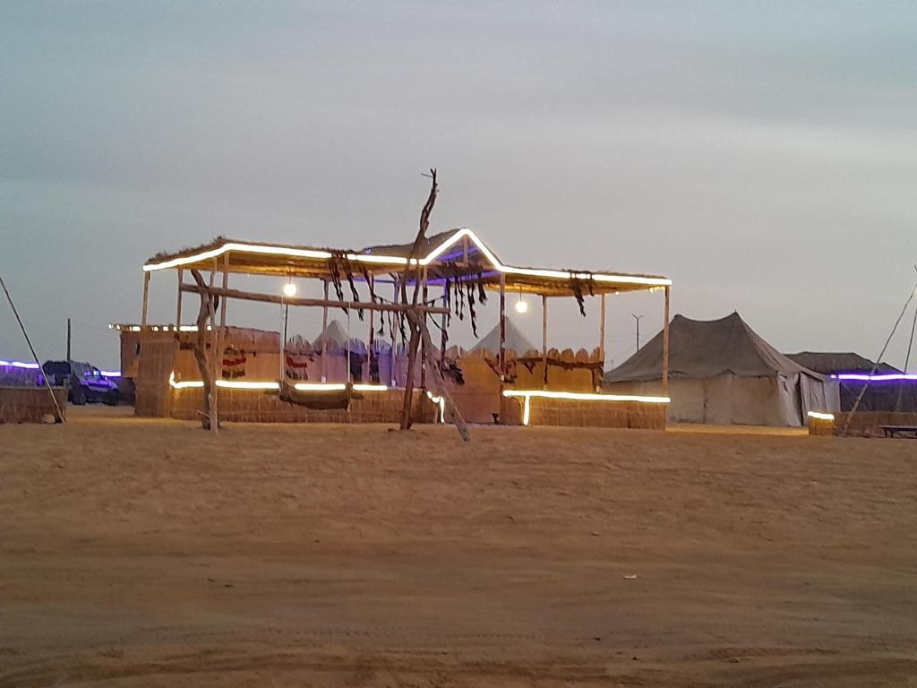 a building with lights on it in the desert at Energy camp in Bawati