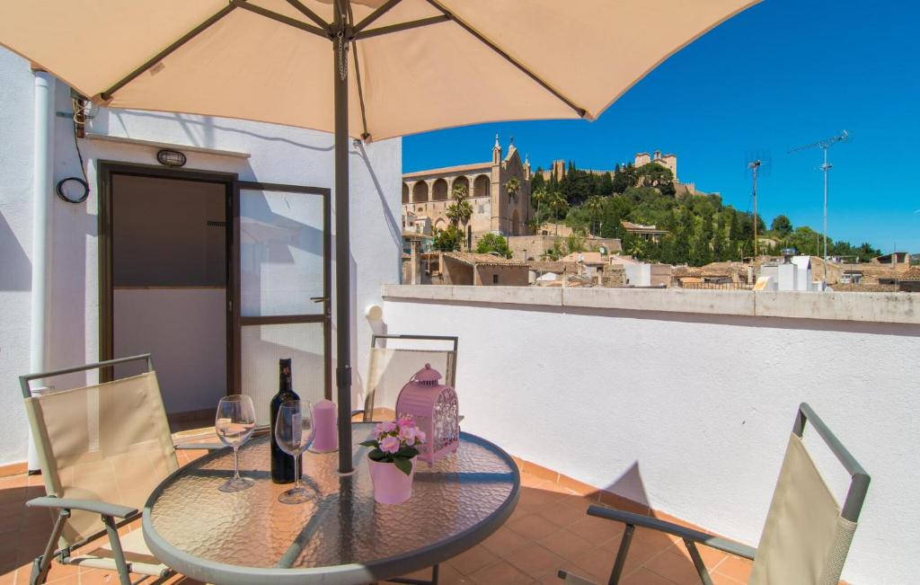 a table with two chairs and an umbrella on a balcony at Roser De Arta in Artá